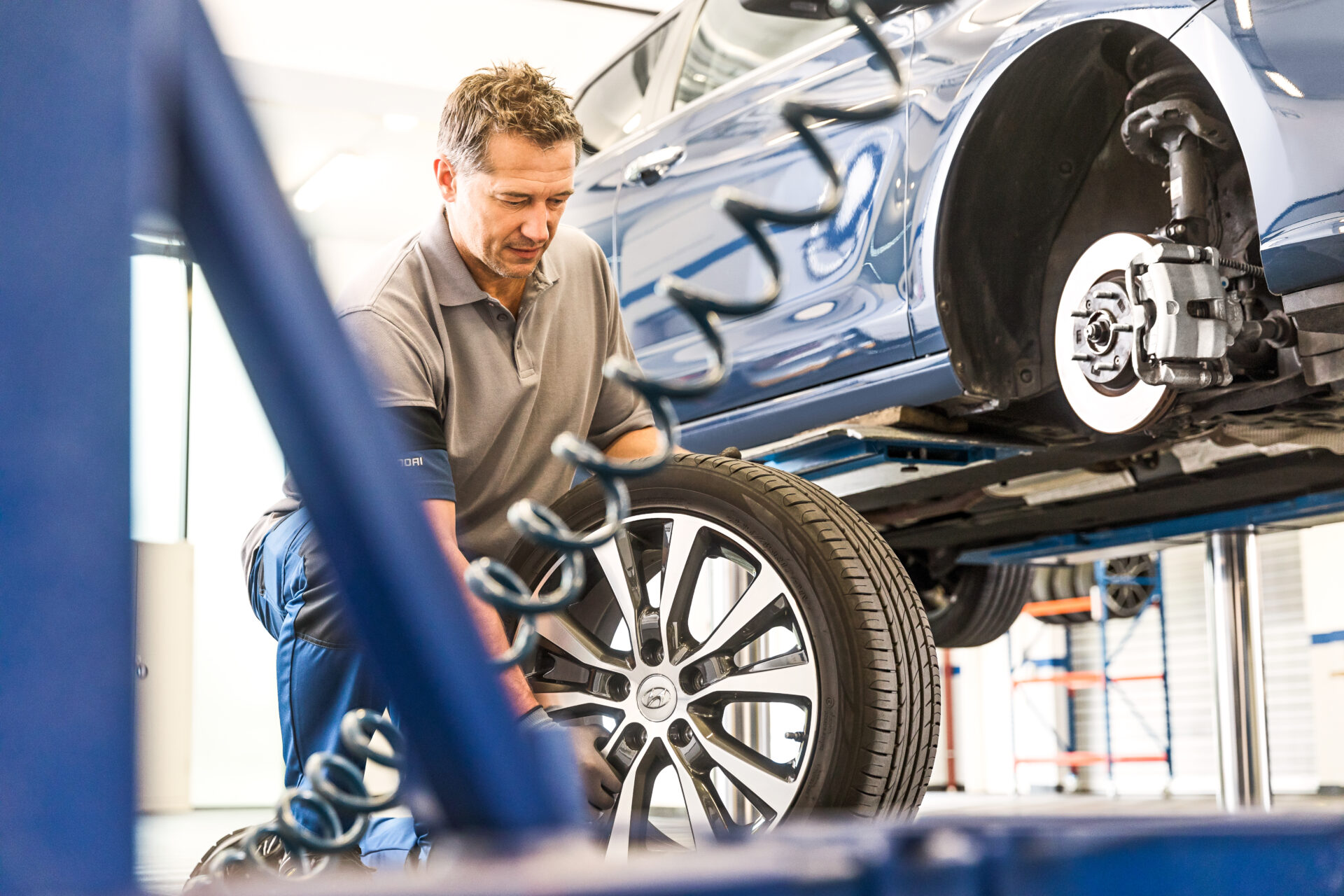 Verkstadsarbetare byter däck på en bil